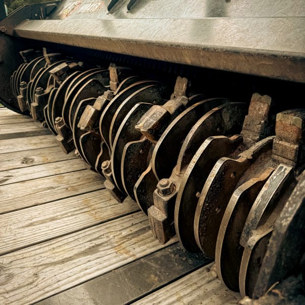 Row of carbide cutting teeth mounted on a forestry mulcher drum.